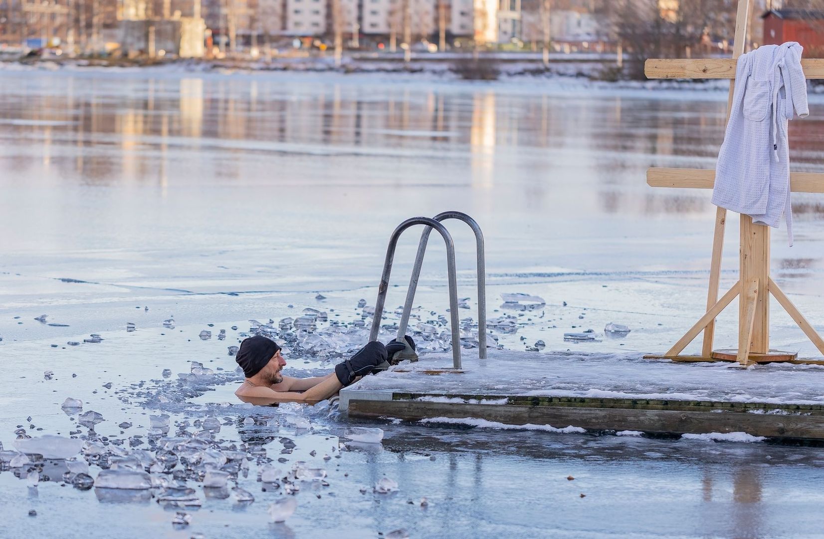 Persoon neemt een koud ijsbad naast een steiger in de winter