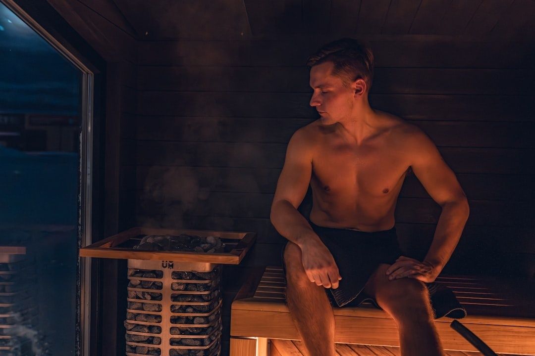 Blote man ontspant op een houten bank in een warme sauna