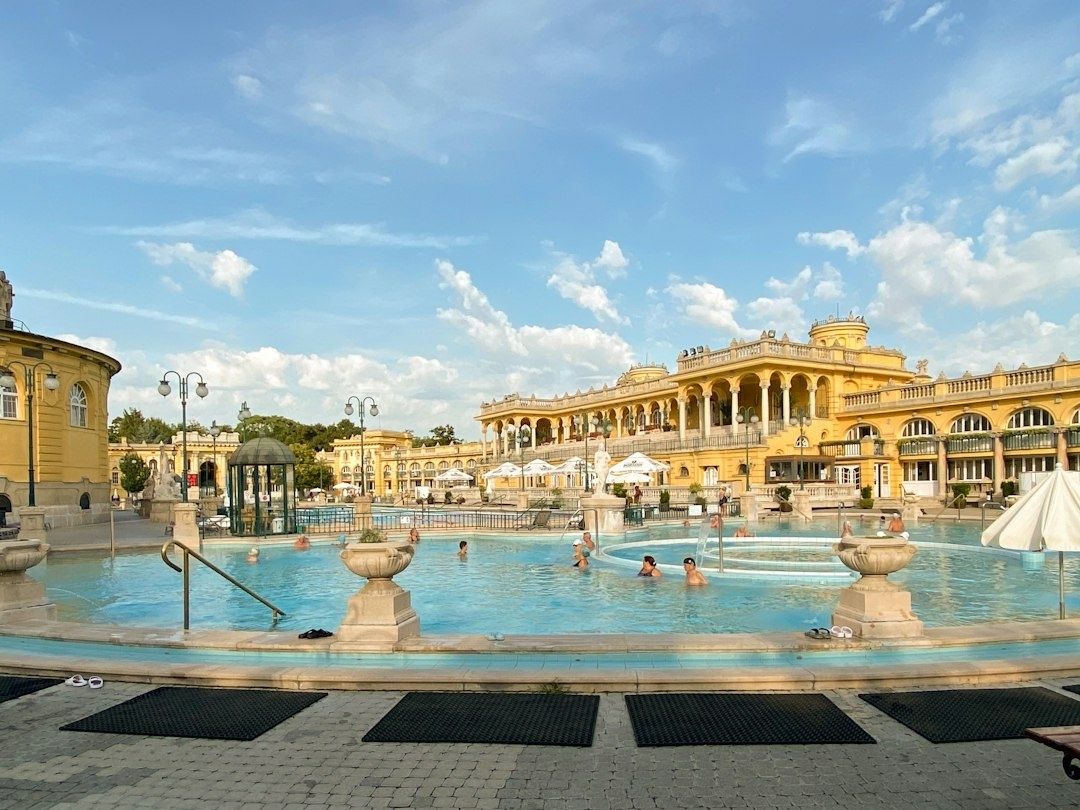 Groot thermaal buitenbad met bezoekers en monumentale wellnessarchitectuur